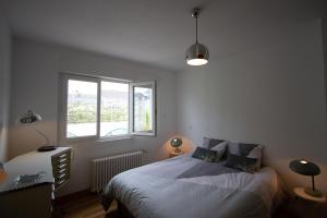 un dormitorio con una cama y una ventana en Les Aigrettes - Appartement spacieux - Terrasse et garage, en Concarneau