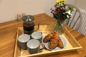 einen Tisch mit Croissants, einer Kaffeekanne und Blumen in der Unterkunft Cavendish Court in York