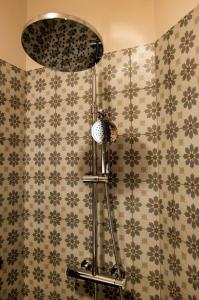 a shower in a bathroom with a tile wall at Il Carro Comfortable Rooms in San Giovanni Gemini