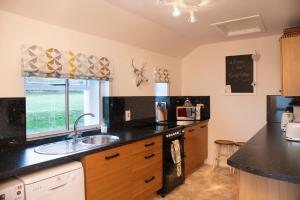 a kitchen with a sink and a counter top at The Corner Cottage in Sandwick