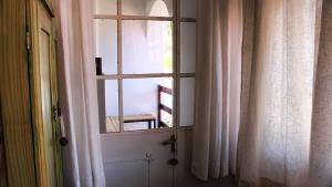 una ventana en una habitación con una silla mirando hacia fuera en Posada San Andres en La Cumbre