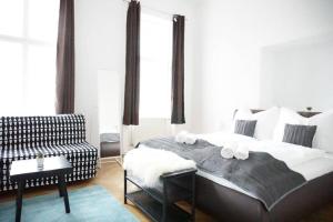 ein Schlafzimmer mit einem großen Bett und einem Sofa in der Unterkunft Urban City Apartment - Contactless Check-In in Wien