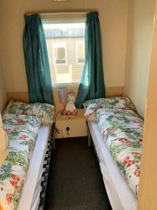two beds in a small room with a window at Boquhanran Caravan, Whitley Bay in Hartley