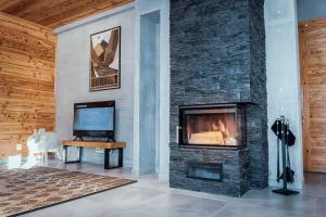 a living room with a fireplace and a television at Flisak in Jaworki