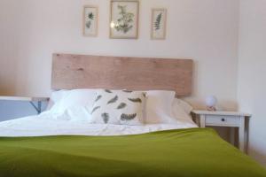 sypialnia z zielonym łóżkiem z dwoma obrazami na ścianie w obiekcie Apartamento completo con parking privado y WiFi en San Roque w mieście Vigo