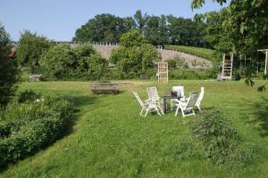 un groupe de chaises et une table dans un champ dans l'établissement Landhaus Ottenberg, à Kressbronn am Bodensee