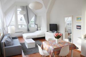 a white living room with a couch and a table at Apartament Central Sopot in Sopot