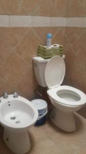 a bathroom with a toilet and a sink at Cabaña del Río in Villa María