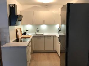 a kitchen with white cabinets and a black refrigerator at 2 Room Messe Kongress Stadion in Dortmund