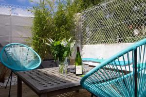 una mesa con una botella de vino y dos sillas en Les Aigrettes - Appartement spacieux - Terrasse et garage, en Concarneau