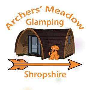 a dog is sitting in front of a dog house at Archers Meadow Shropshire in Ellesmere