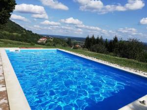 a large blue swimming pool with a view at Holiday Home Luka 10 in Kalnik +36 photos