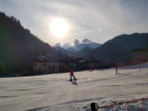 una persona che cavalca uno snowboard lungo una pista innevata di CASA LAGHETTO a Bovegno