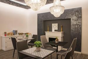 a dining room with tables and chairs and chandeliers at Double A Guest House in Mestre