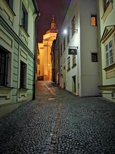 an empty street at night with a building in the background at Hotel Penzion Na Hradě in Olomouc