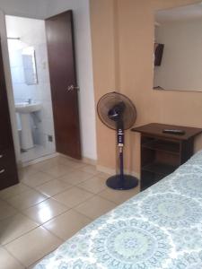 Habitación con 1 dormitorio con ventilador y baño. en Hospedaje Marita, en Lima