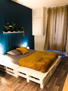 uma cama grande num quarto com uma parede azul em chambre double avec salle de bain privative em Cognac
