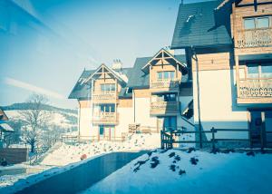 a group of buildings with snow on the ground at Bury Miś in Jaworki