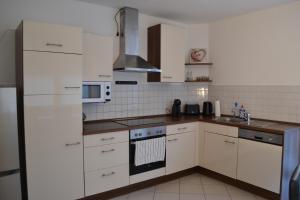 a kitchen with white cabinets and a stove top oven at FeWo Kleeblatt mit eigener Terrasse in Wuppertal