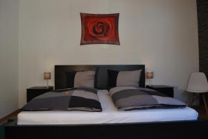 a bed with two pillows and a painting on the wall at FeWo Kleeblatt mit eigener Terrasse in Wuppertal