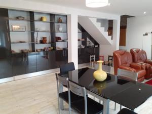 a dining room with a black table and chairs at Casa das Relvas in Penalva de Alva