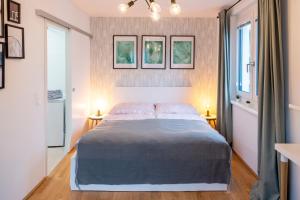 Green & cozy apartment - 15 min to city center في فيينا: غرفة نوم بسرير كبير ومصباحين