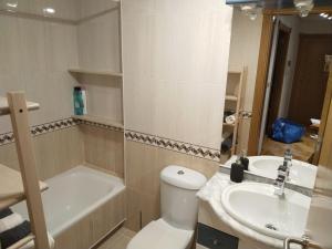 a bathroom with a toilet and a sink and a tub at Apartamento Anjelus in Mutriku