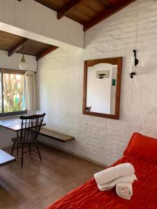 1 dormitorio con cama, mesa y espejo en Miraverde en Pinamar