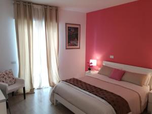 ein Schlafzimmer mit einem großen Bett und einer roten Wand in der Unterkunft Dimora Francesca in Conversano