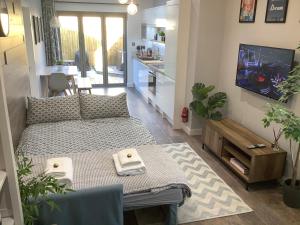 a small living room with a bed and a table at Carolyn’s Place in Ruislip