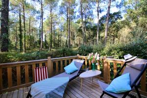 une terrasse en bois avec une table et des chaises. dans l'établissement Espace Blue Océan, à Ondres