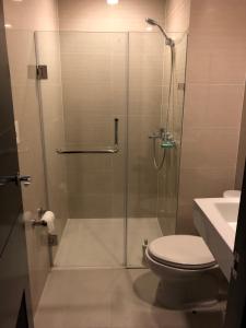 a bathroom with a shower with a toilet and a sink at Modern and Cozy Studio near Airport Terminal 3 in Manila