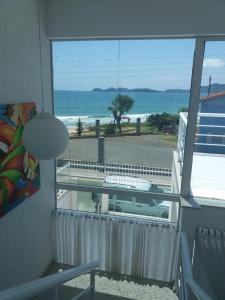 Habitación con ventana con vistas a la playa. en CASA DE VIDRO PERFEITA A 25 METROS DA PRAIA, en Penha