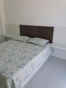 1 cama con cabecero de madera y almohadas en CASA DE VIDRO PERFEITA A 25 METROS DA PRAIA, en Penha