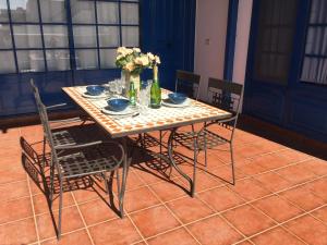 een tafel met een vaas met bloemen erop bij Casa Sol Azul in Puerto Calero
