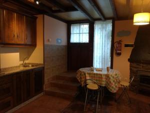 una cucina con tavolo, lavandino e finestra di Luna de Vilar a Vilarpescozo