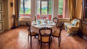 ein Esszimmer mit einem Tisch, Stühlen und einem Sofa in der Unterkunft Villa Nuba, residenza del Pinturicchio con terrazza panoramica privata, camino a legna,jacuzzi in Perugia