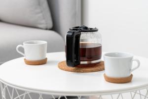 オウルにあるULEABO Modern 37m2 Studioのコーヒーメーカー、テーブルの上に2杯