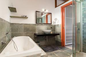 La salle de bains est pourvue d'une baignoire, d'un lavabo et d'un miroir. dans l'établissement La Cesa Case Vacanza, à San Felice Circeo