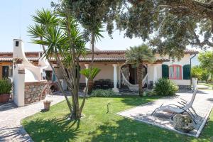 a house with a palm tree in the yard at La Cesa Case Vacanza in San Felice Circeo