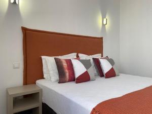 - une chambre avec un lit doté d'oreillers rouges et blancs dans l'établissement Urban art Lagos, à Lagos