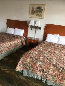 a hotel room with two beds and two lamps at Moon Mist Motel in Meade