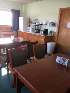 une salle à manger avec des tables et des chaises ainsi qu'une cuisine dans l'établissement Moon Mist Motel, à Meade