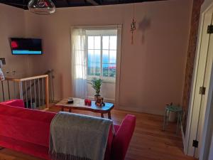 a living room with a red couch and a table at vivienda vacacional Benilde in Breña Alta