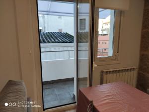 Habitación con puerta corredera de cristal y ventana en Villa Trabazos Abellas, en Ourense