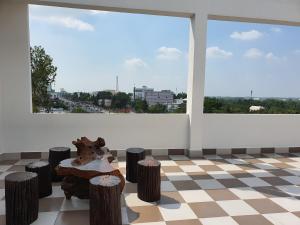 a room with large windows and a table and stools at An Nhiên Hotel in Tây Ninh