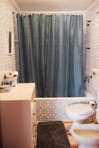 a bathroom with a toilet and a shower curtain at Escapadinha da Estrela - Penhas da Saúde in Penhas da Saúde +23 photos
