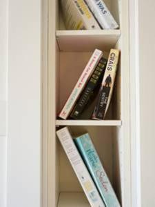 een boekenplank gevuld met boeken in een koelkast bij Peaceful Top Floor Apt W Balconies - Cambridge RIGHT - AC in Funchal