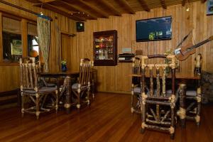 a dining room with a table and chairs and a television at Casa Azul Hostel in Puerto Varas