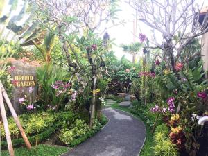 un passaggio attraverso un giardino con fiori e piante di Kartika Dahayu Private Pool Villas a Sukawati